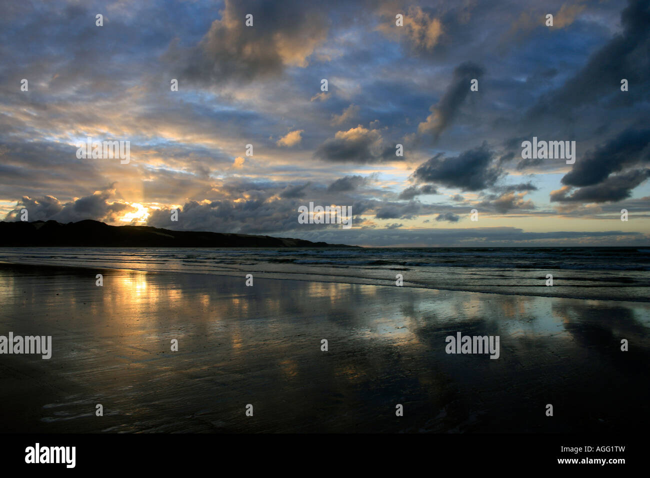 Sunset over sand dunes at Ahipara Ninety Mile Beach New Zealand Stock Photo