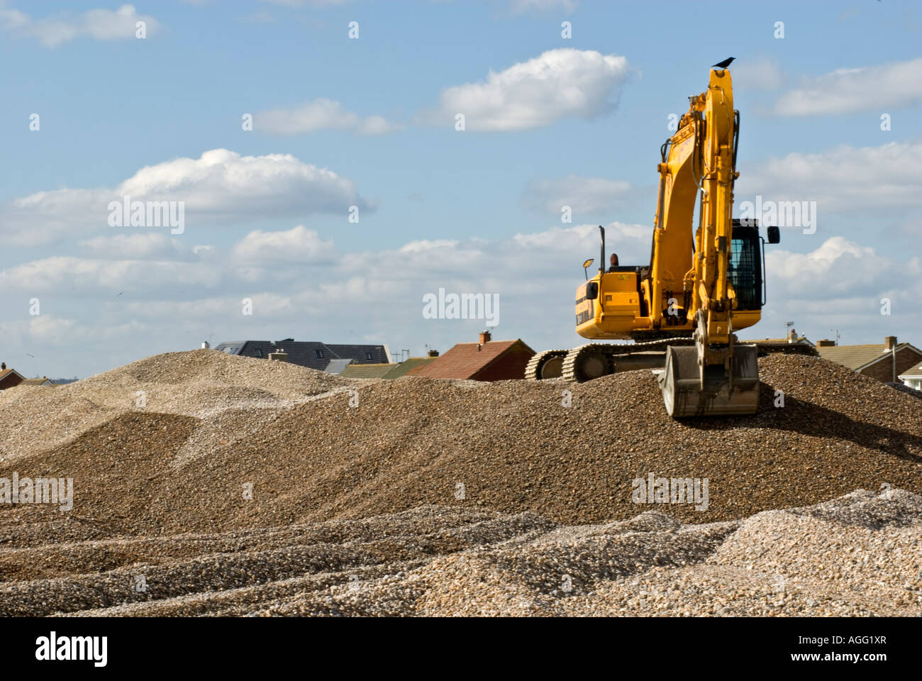 YELLOW EXCAVATOR MOVING SHINGLE WORKING ON THE BEACH Stock Photo - Alamy