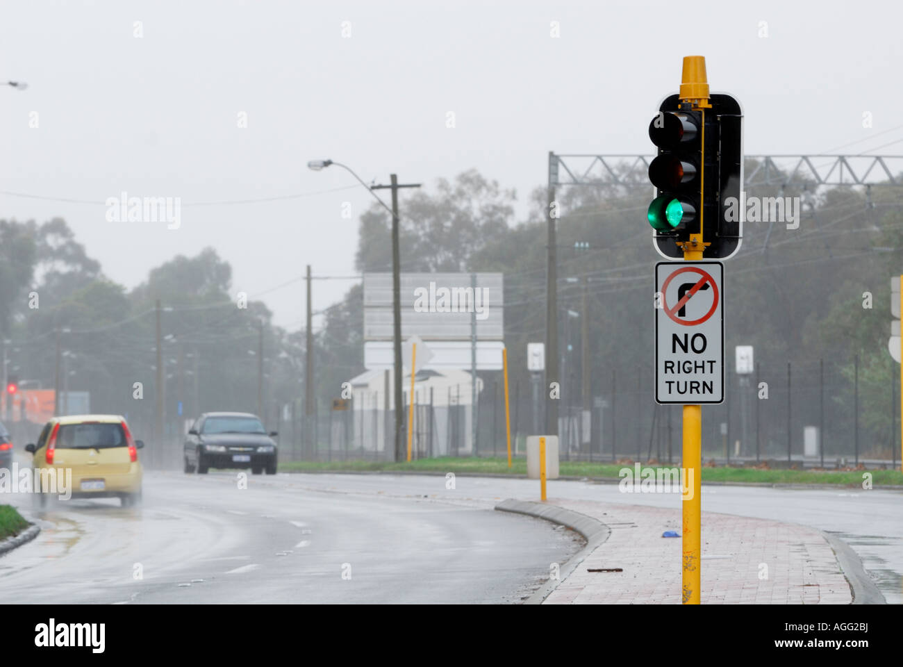 green traffic light and 'NO right turn' sign in rain Stock Photo