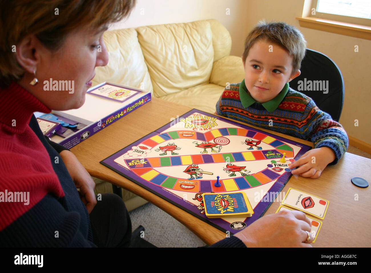 child playing articulation board game with speech therapist Stock Photo