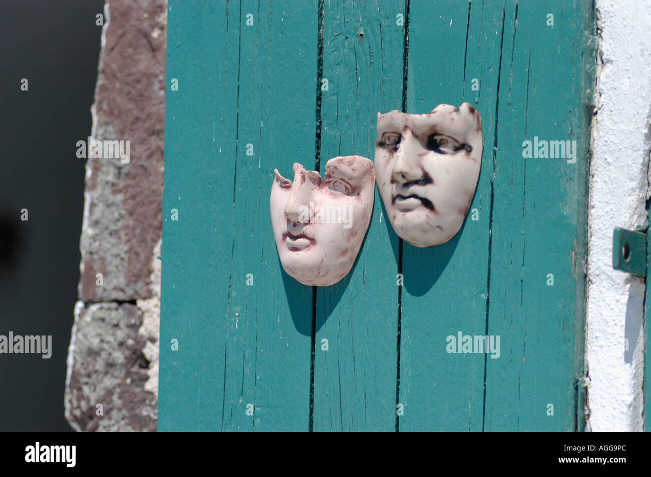 artistic masks hanging on wall in souvenir shop, village of Oia