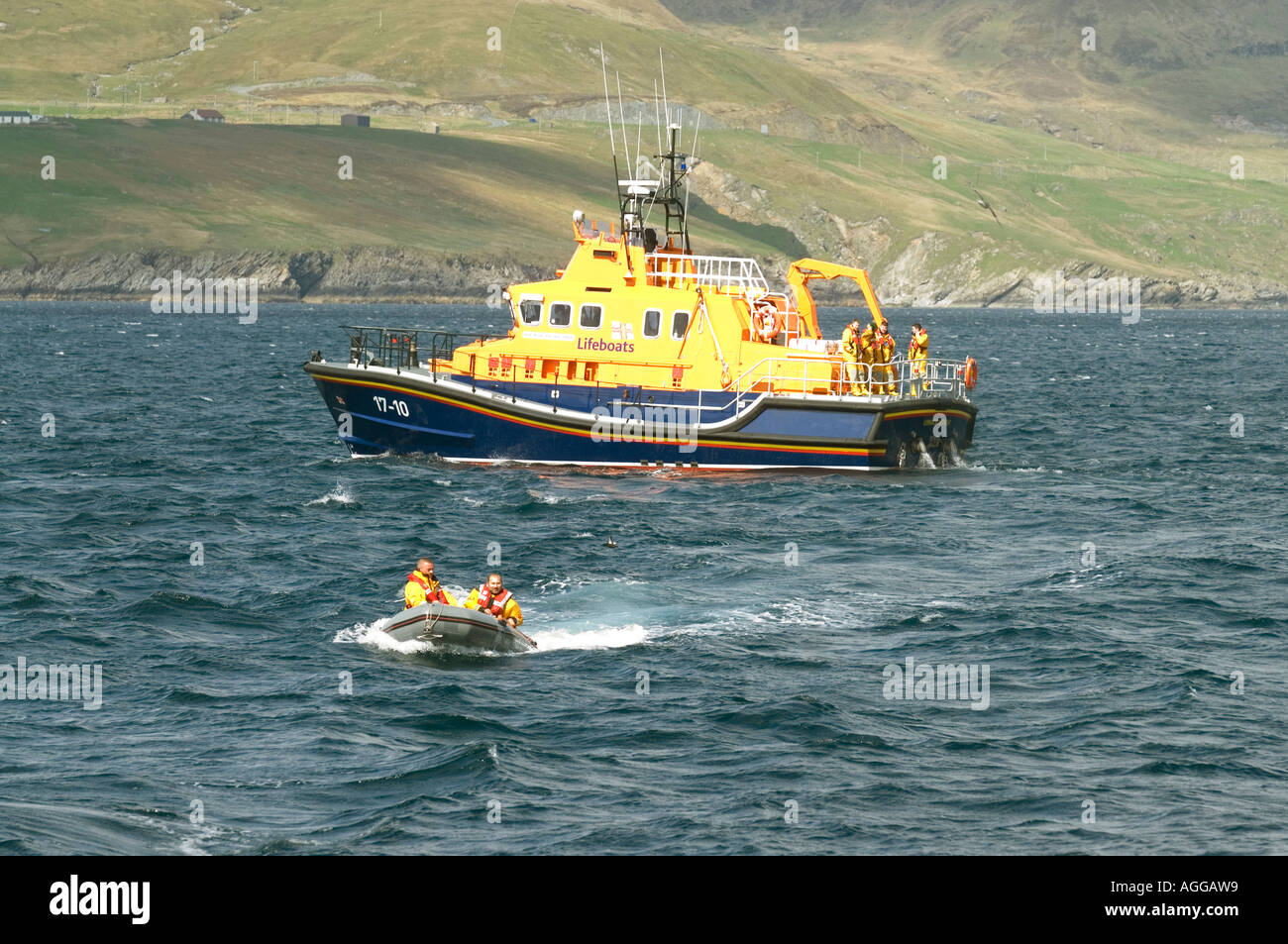 The Lerwick lifeboat the Michael and jane Vernon moored off Mousa in the Shetland isles with dingy heading for shore Stock Photo