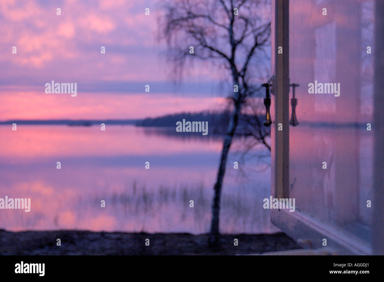open window with view over lake at dusk, Sweden Stock Photo
