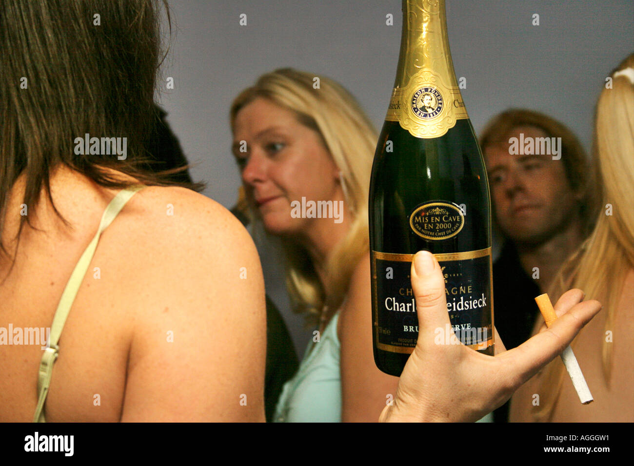 champagne cigarette Girl with a bottle of champagne and a cigarette at a party Stock Photo
