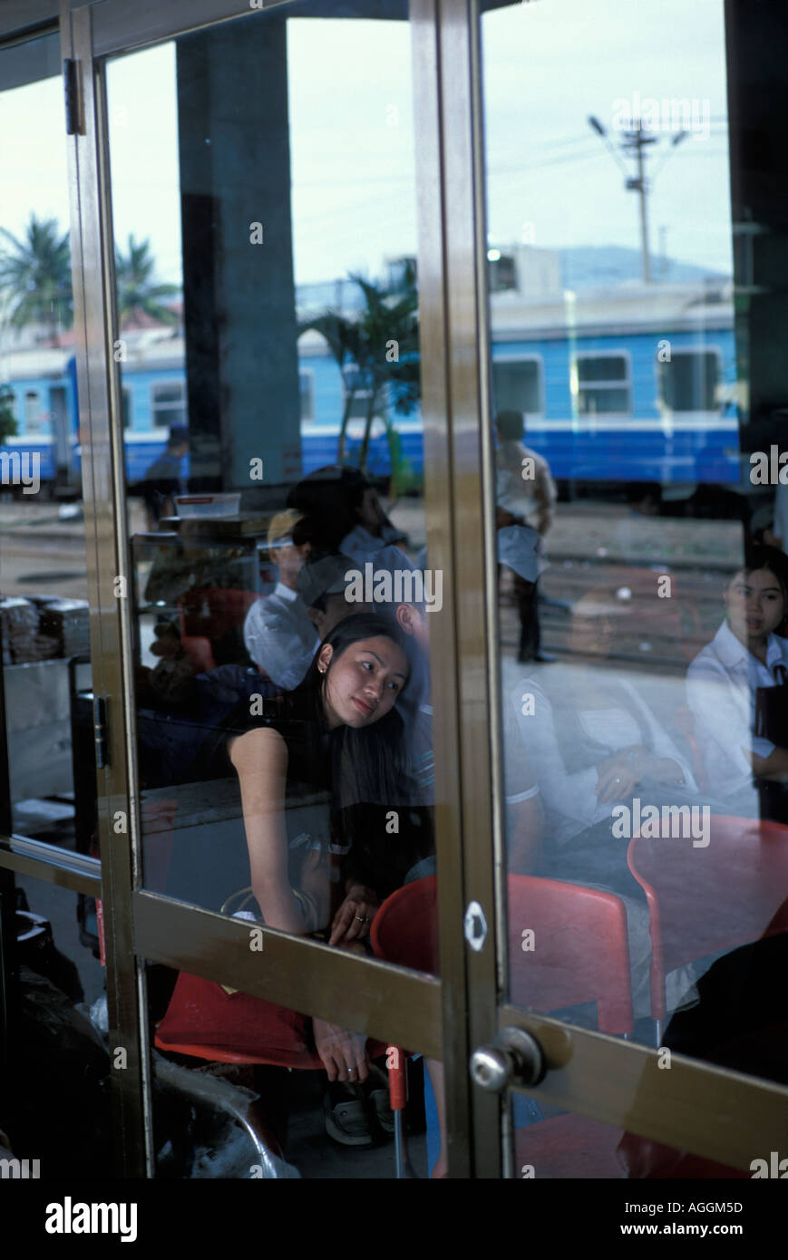 Asia Vietnam Hué Woman sits in Central train station as Reunification Express train arrives Stock Photo
