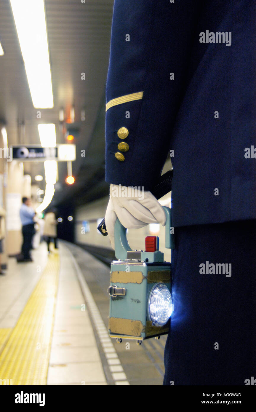 train attendant/stationmaster with signal lamp, Tokyo, Japan Stock Photo