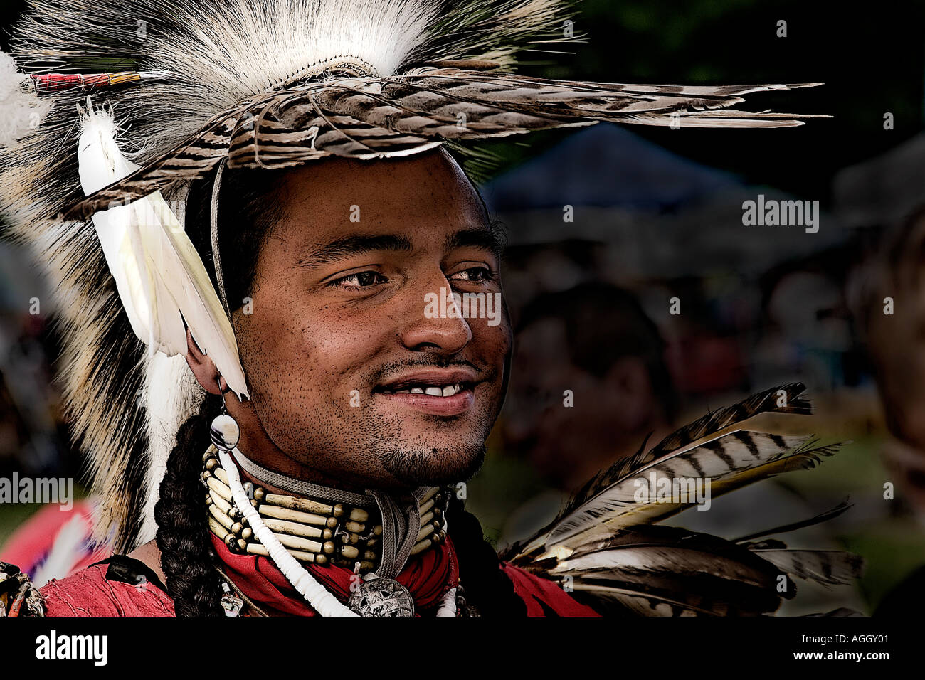 Native American man in full dress at a powwow traditional dance competition wearing feathered headdress and jewelry Stock Photo