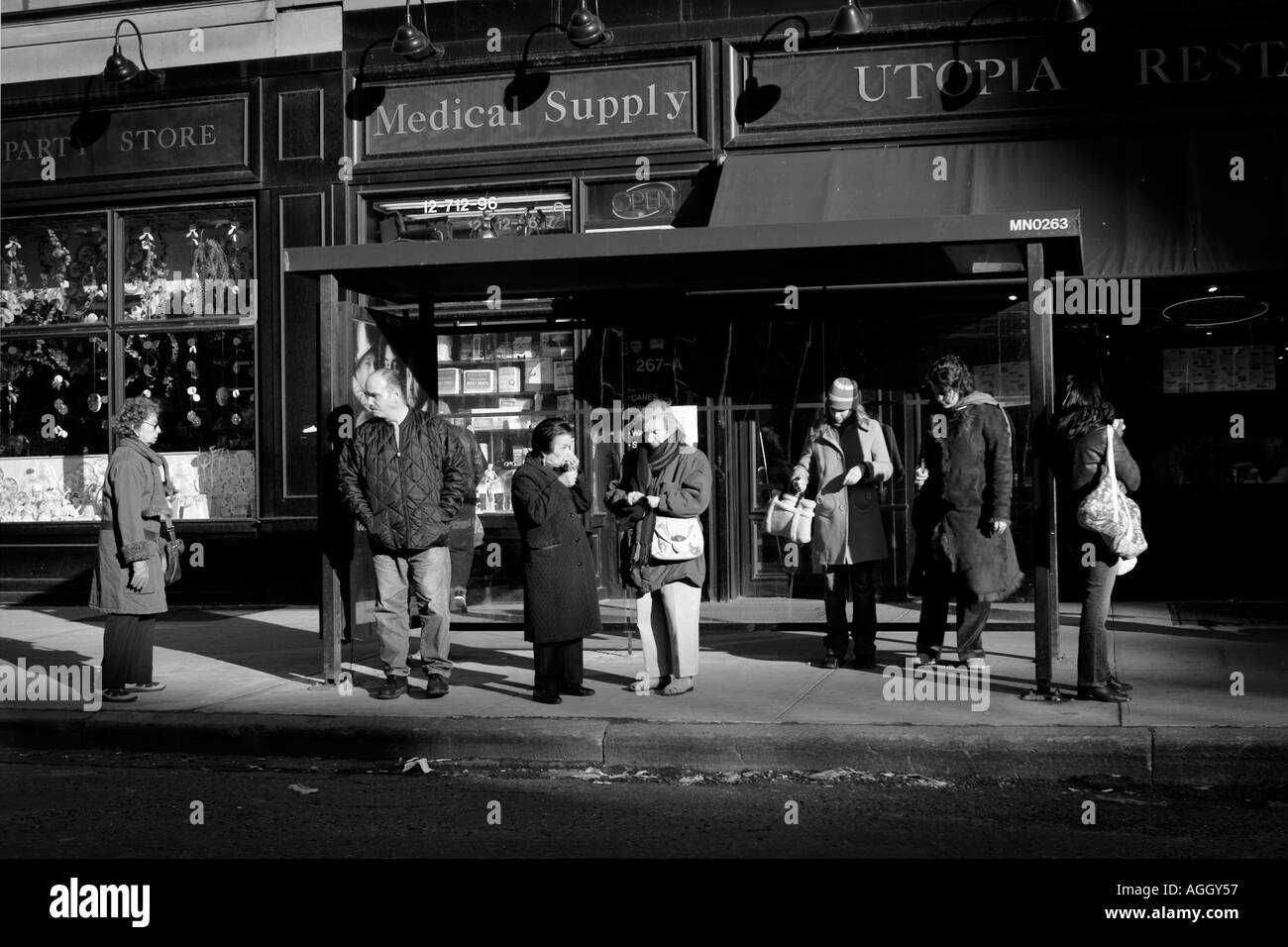 street scene in black white New York City people waiting for a bus in a bus stop Stock Photo