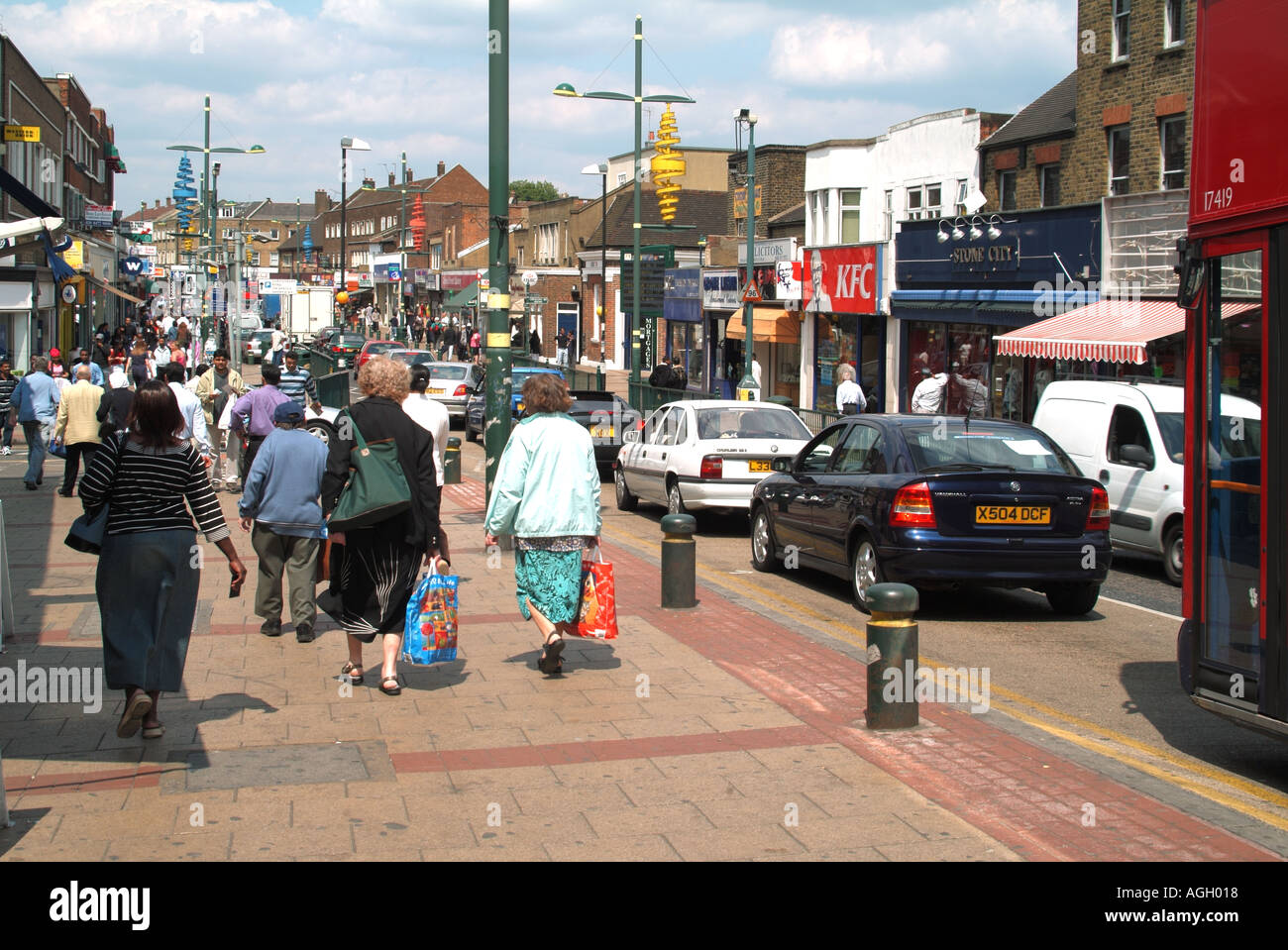 Close up people shoppers on pavement beside road traffic in Green Street a scene in busy