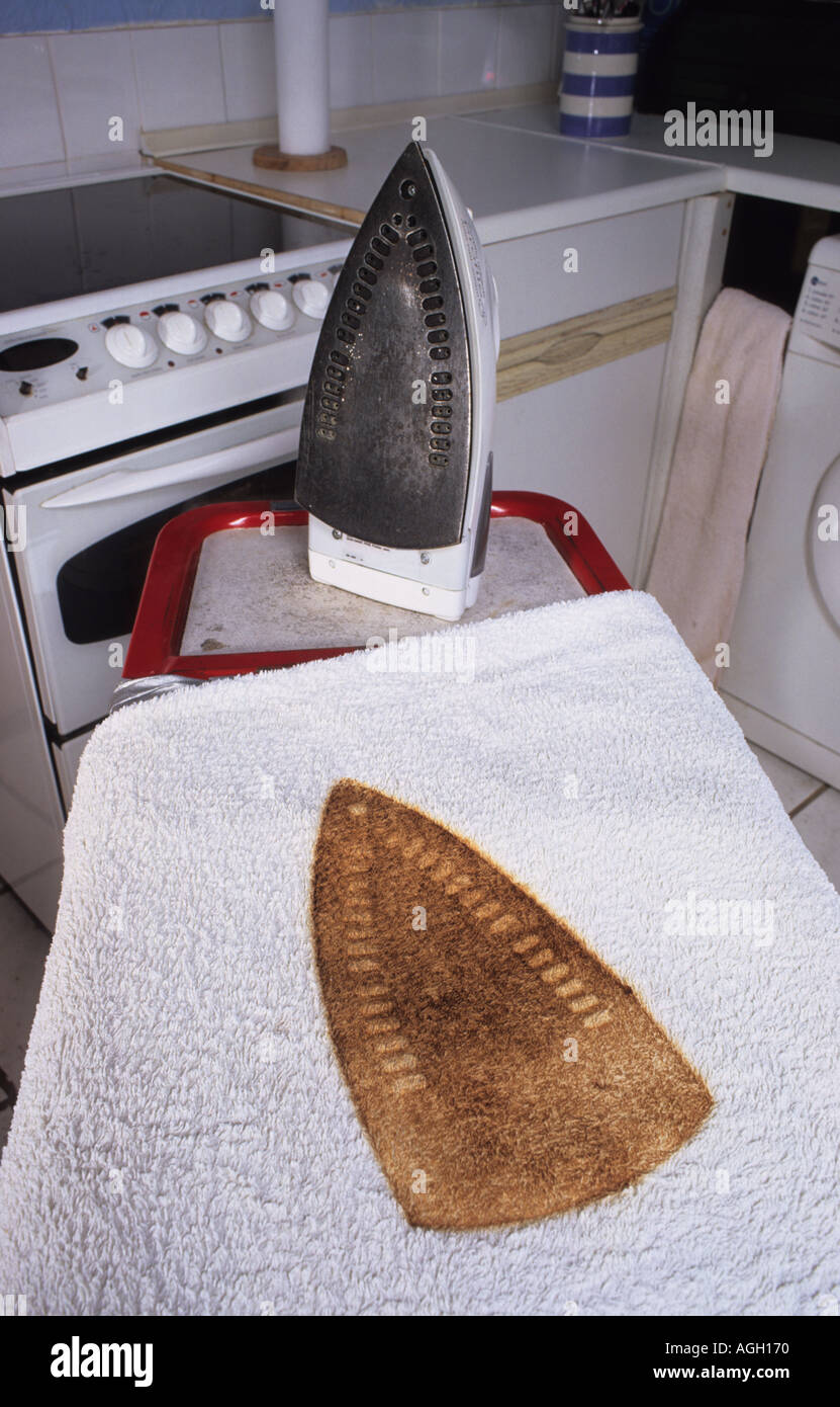 burnt outline of iron left on towel too long on ironing board in kitchen Stock Photo