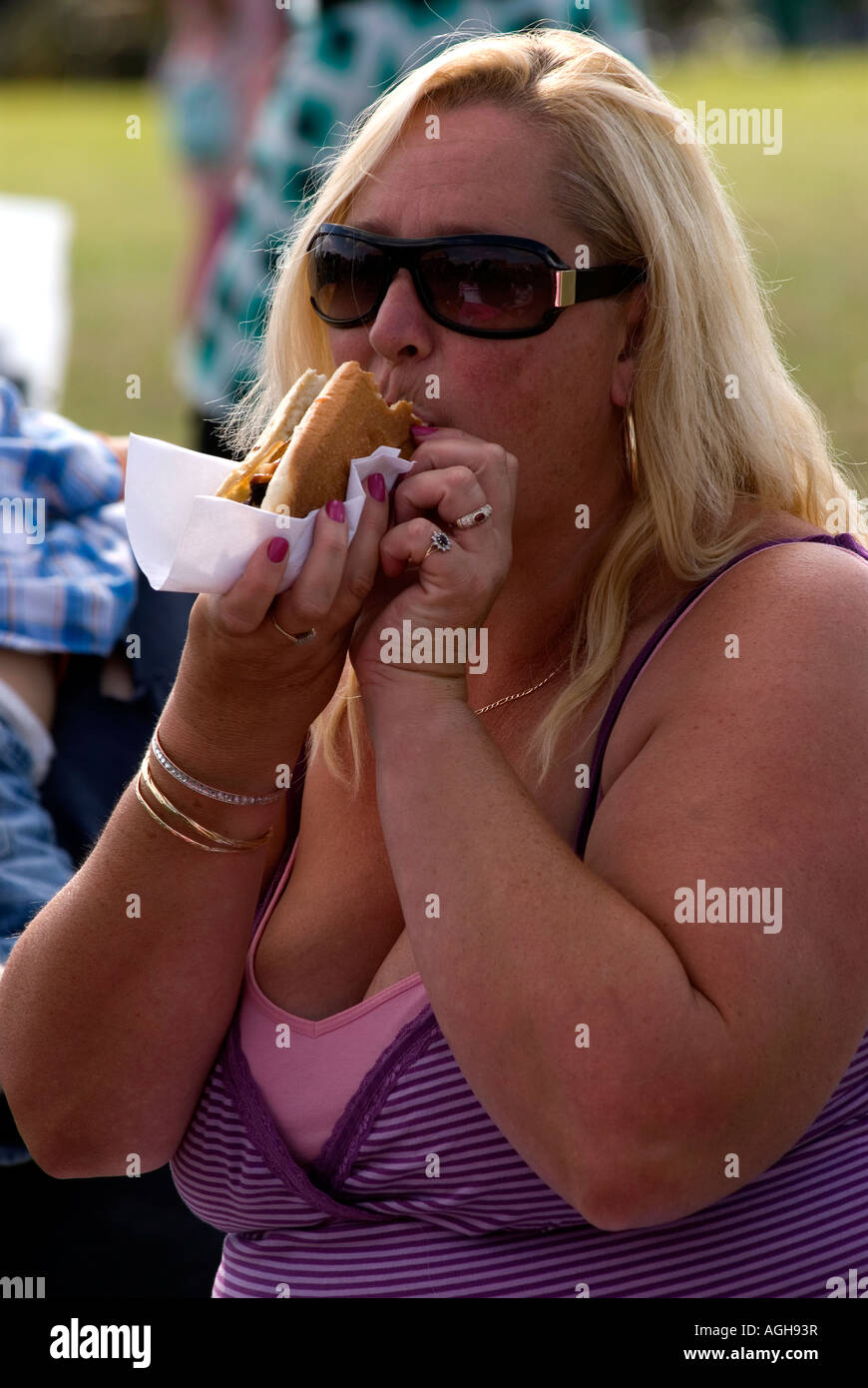 42 year old woman eating a hot dog at a community fun day in Heston, Middlesex, UK. Stock Photo