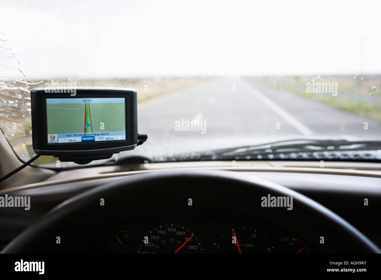 Vehicle dashboard with GPS and view through windshield of highway ahead