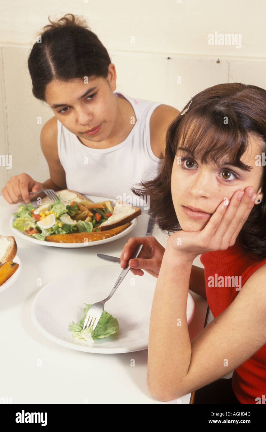 teenage girl eating a very small portion at a family meal Stock Photo