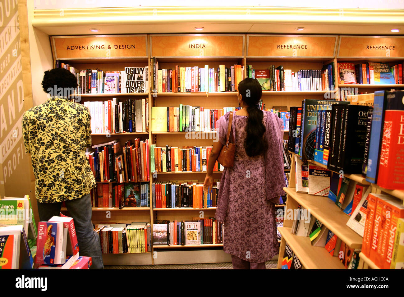 Two book lovers standing man women looking at book shelf at modern latest bookshop in Bombay India Stock Photo