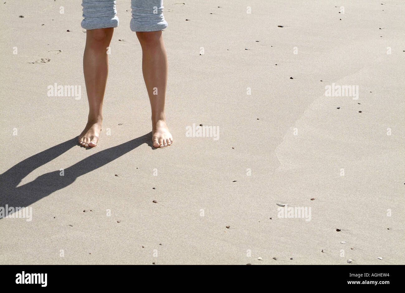 Woman standing on beach low section Stock Photo