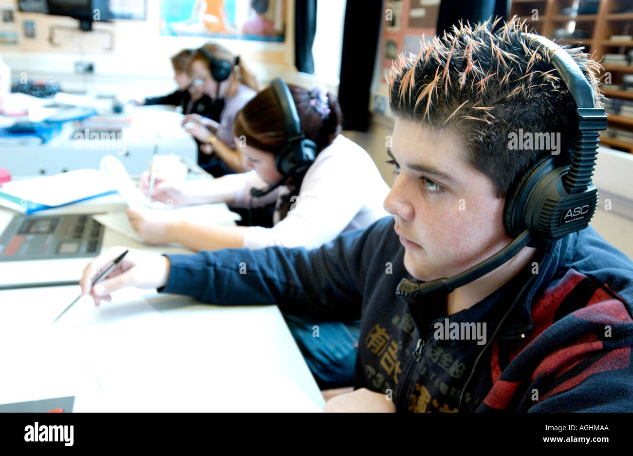 Teenage boy in language laboratory concentrating on Spanish lesson