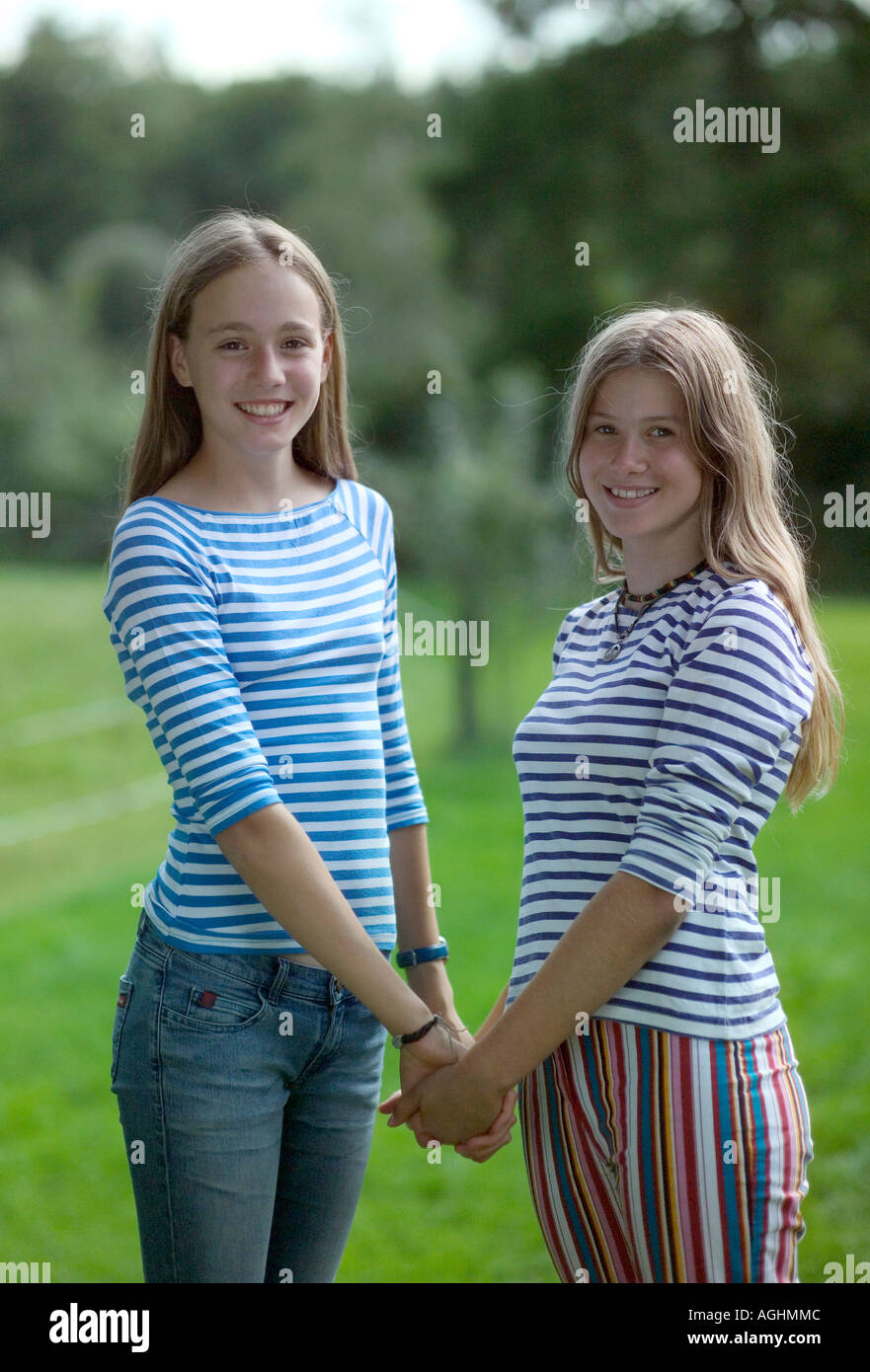 Teenage girls holding hands smiling portrait Stock Photo - Alamy