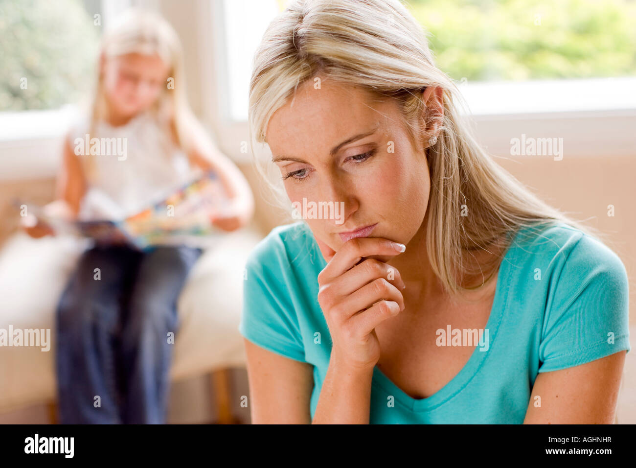 Mother looking worried with her daughter in the background Stock Photo