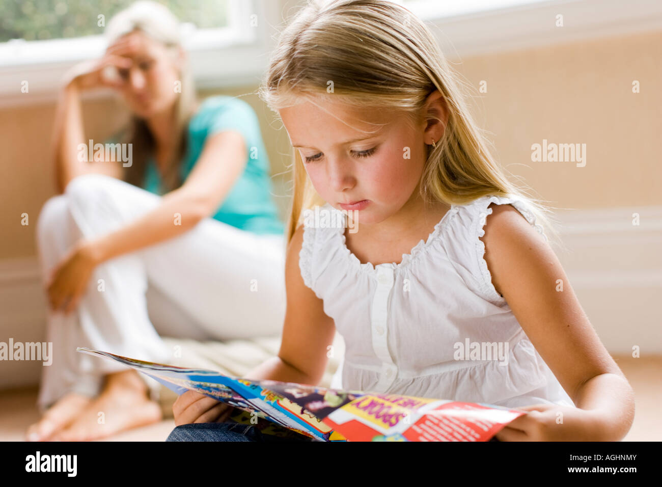 mother looking worried with her daughter in the foreground Stock Photo