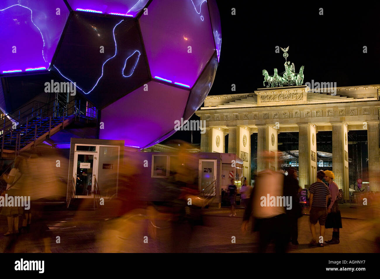 People walk by a glowing soccer ball  sculpture in front of Brandenburg gate during  the 2006  World Cup, Berlin, Germany Stock Photo