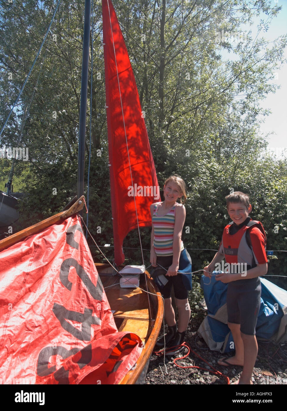 Children rigging the sails and mast on a mirror class sailing dinghy