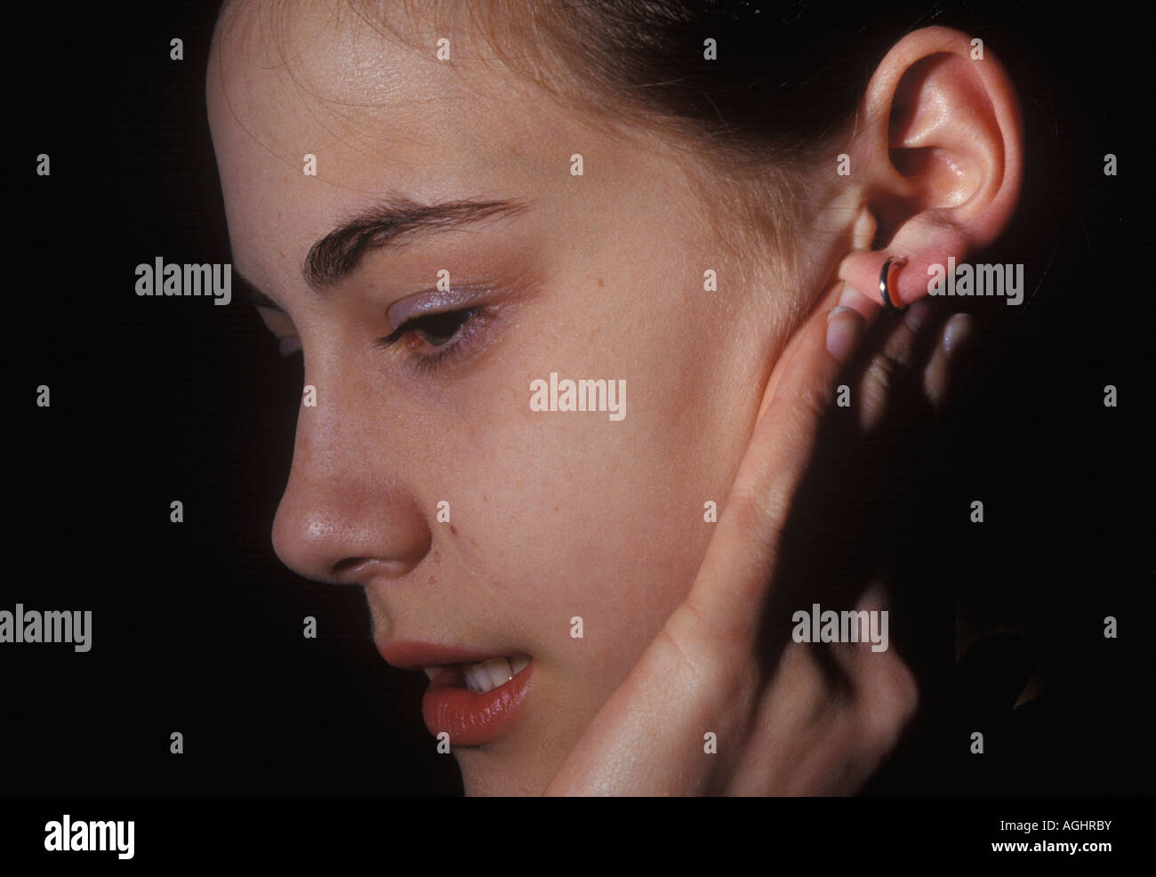 teenage girl playing with an infected earing Stock Photo