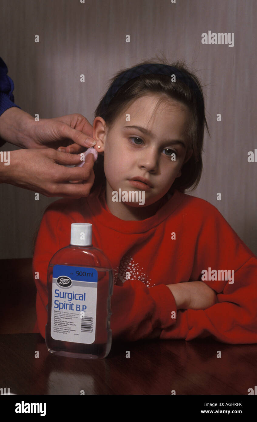 girl having her pierced ears bathed with surgical spirit Stock Photo Alamy