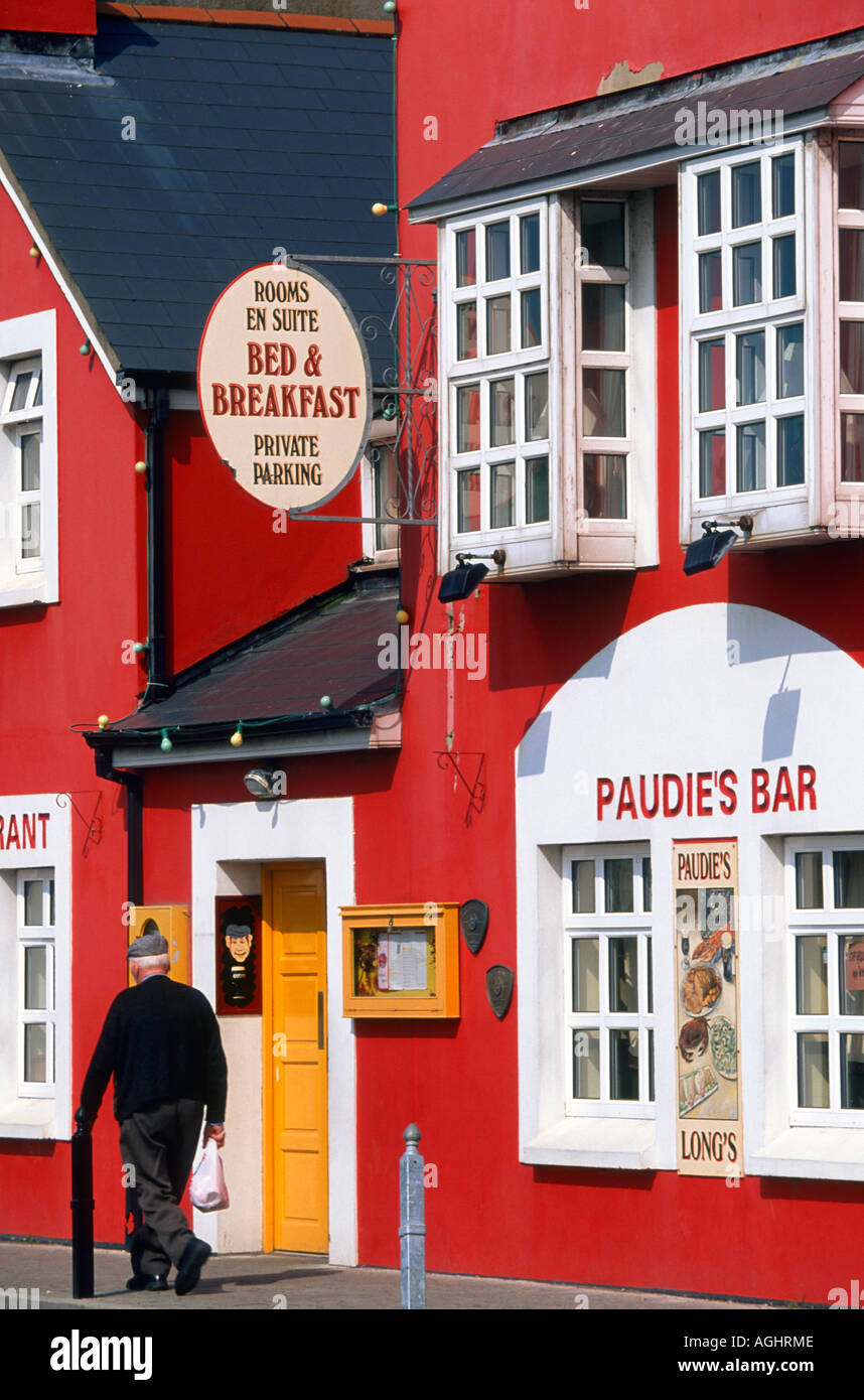 Man walk infront of a restaurant and Paudie's bar at Strand Street. Dingle Ireland County Kerry Europe Stock Photo