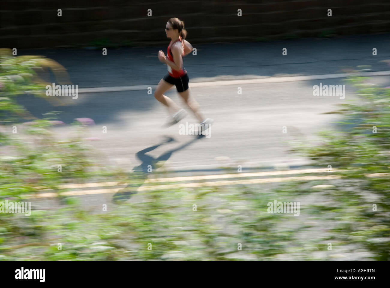 a motion blur pan shot of a female jogger during a road race Stock Photo -  Alamy