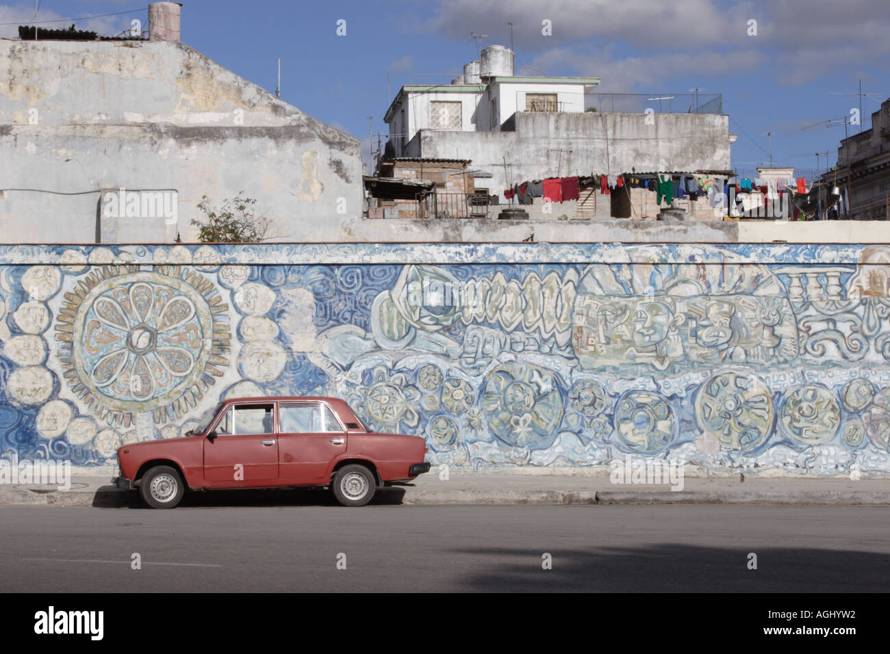 Red Lada parked by a mural in Havana, Cuba Stock Photo