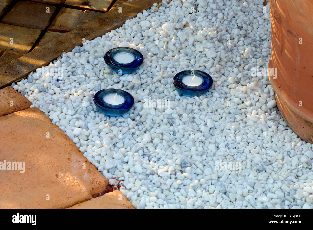 candles set into white gravel mulch Stock Photo