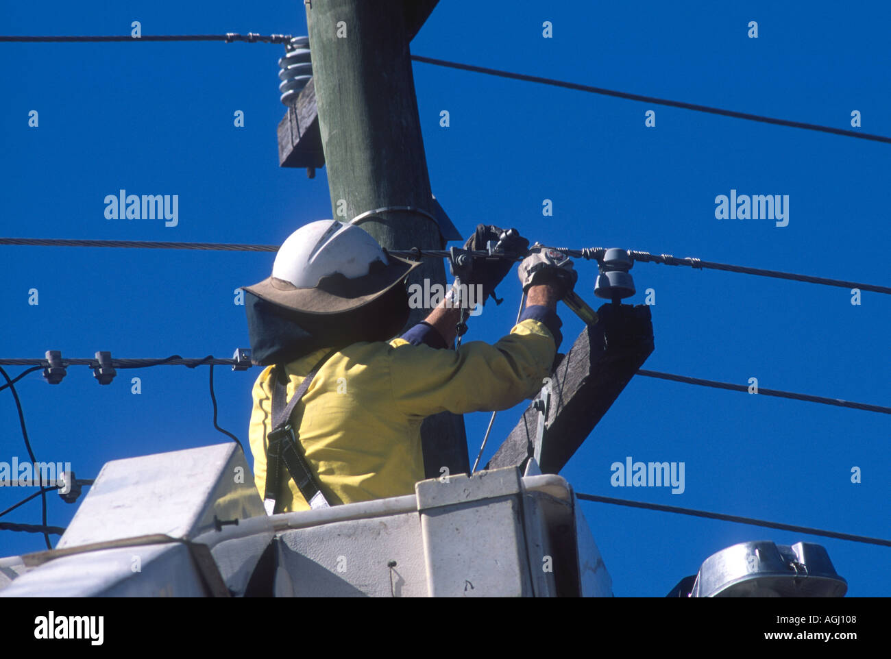 Electricity Worker in Elevated work platform fixing powerlines Stock