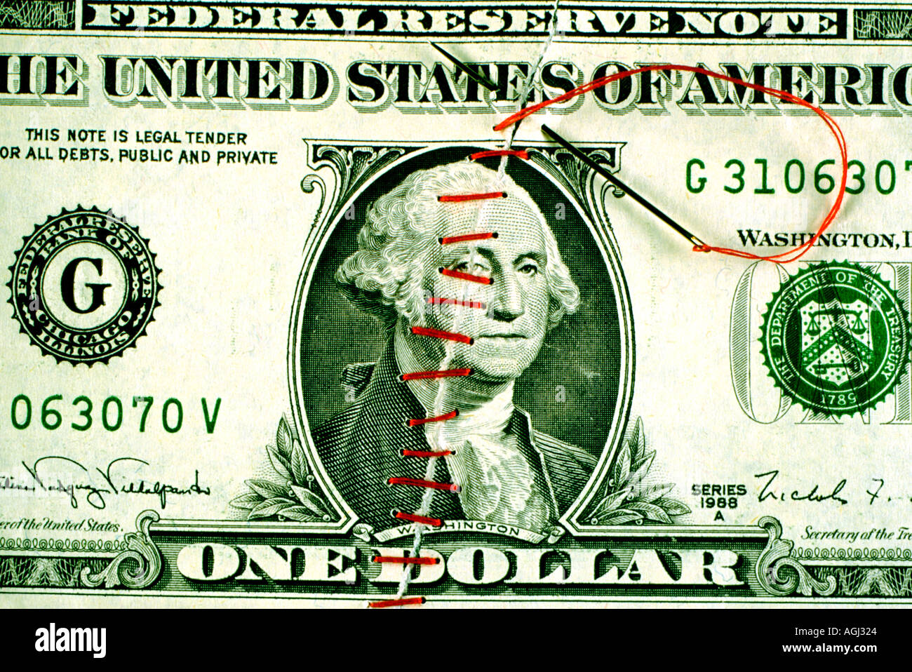 Ripped United States dollar bill sewn together with red thread Stock
