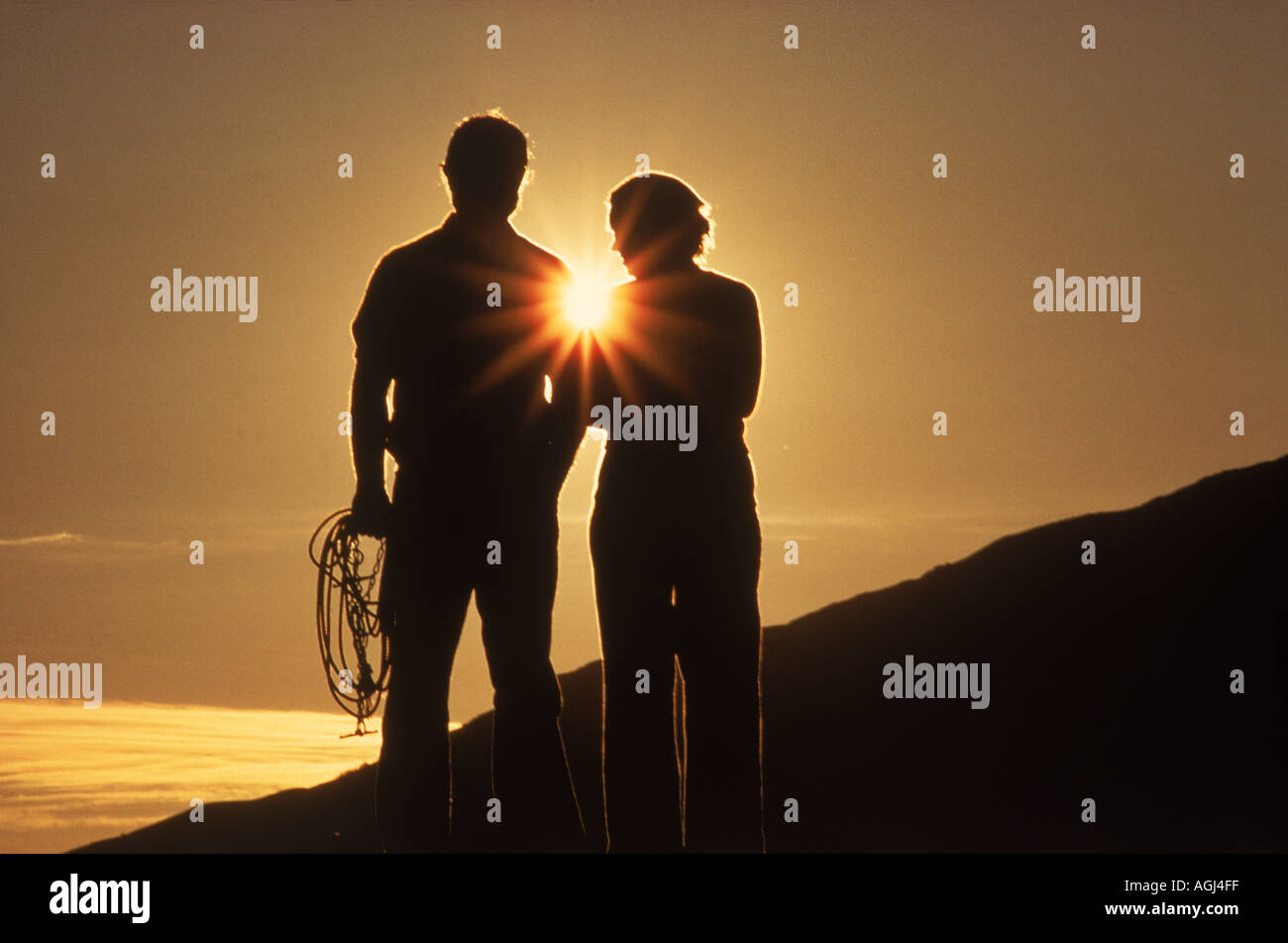 Couple standing on hillside in Norway at sunset Stock Photo