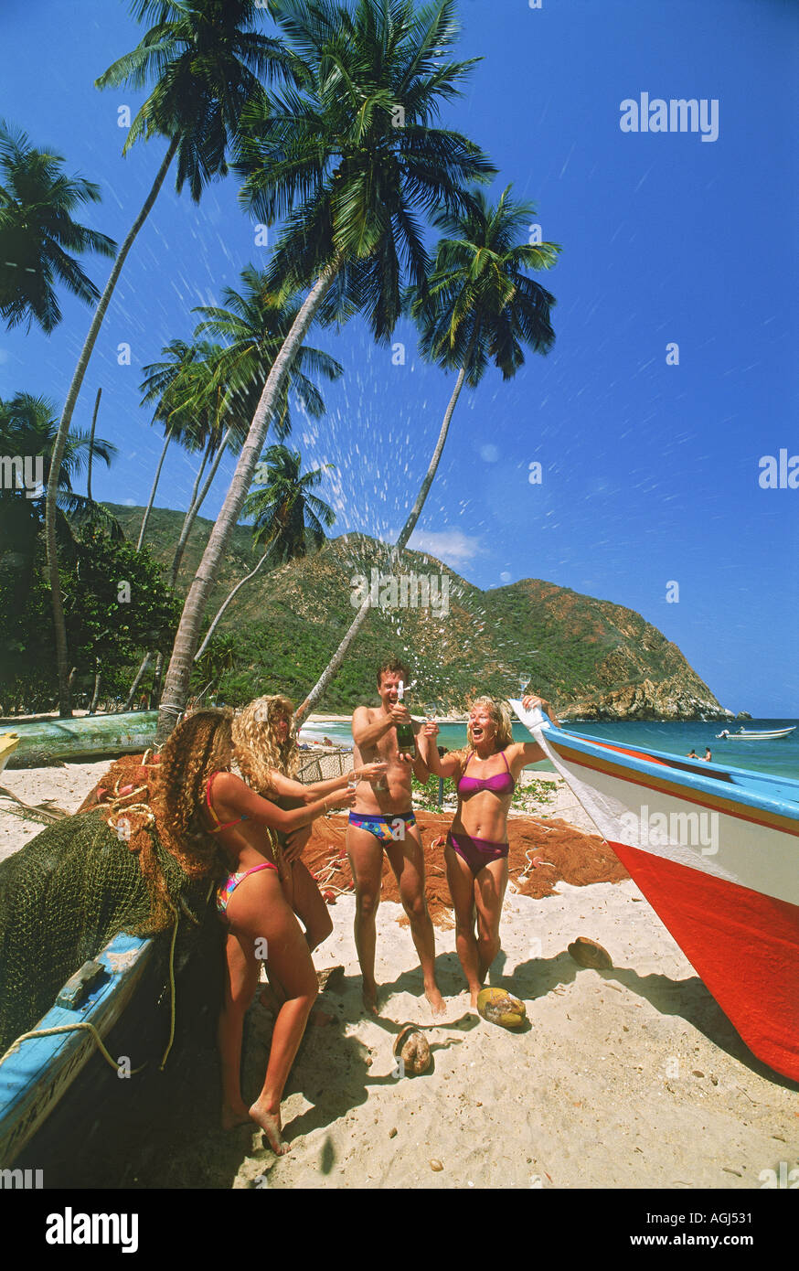 Fishing boats and friends on Caribbean beach at village of Choroni in Venezuela three hours west of Caracas Stock Photo