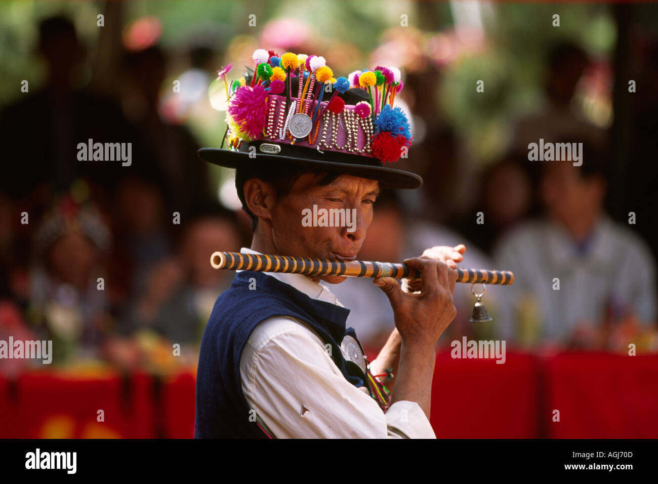 China Yunnan Xiao Hu La Akha Hani village man playing flute for festival dancing Stock Photo