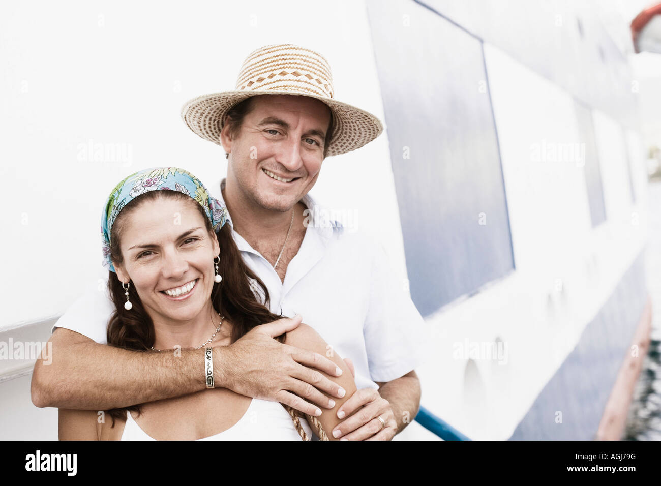 Portrait of a mid adult man embracing a mid adult woman from behind and ...