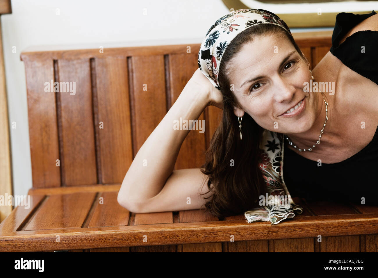 Portrait of a mid adult woman lying on a bench and smiling Stock Photo ...