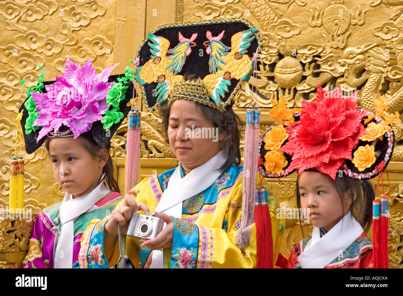 asia china mother with tow children in traditional clothes being photographed Stock Photo