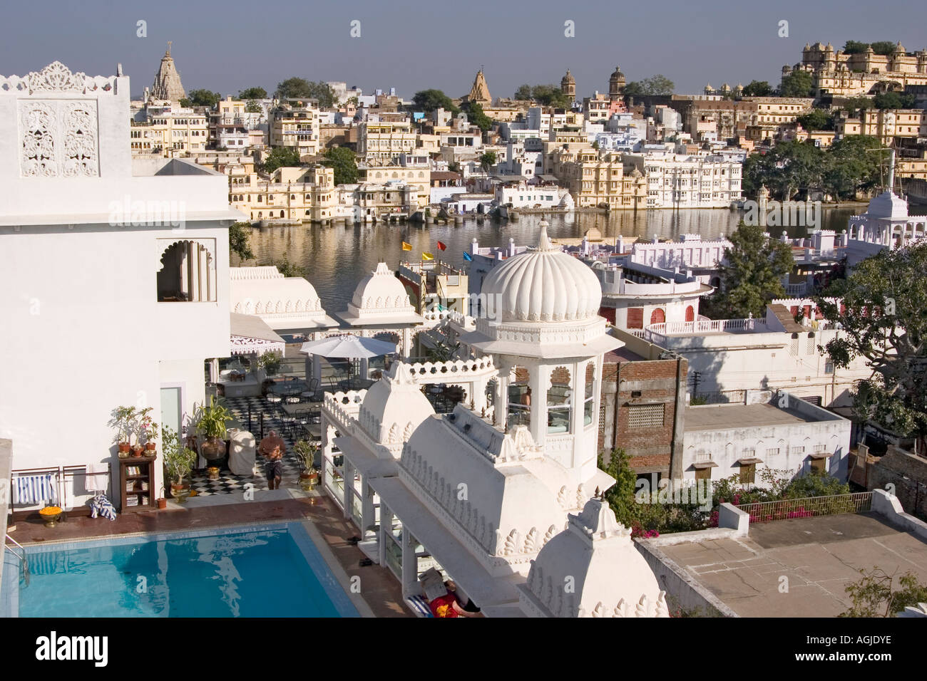 india view on the swimmingpool of the hotel udai khoti with the city palace of udaipur in the background Stock Photo