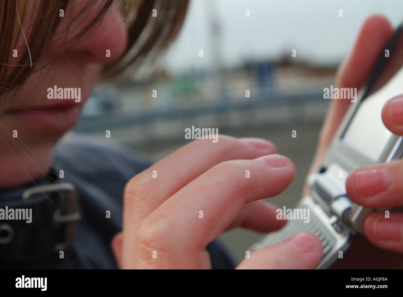 a girl typing a text message on a mobile phone Stock Photo