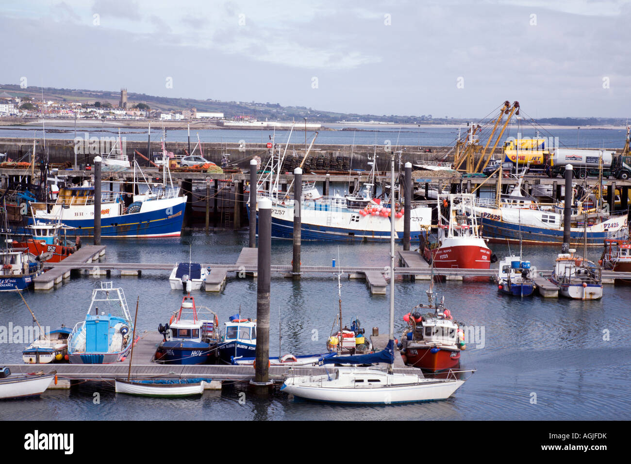The busy harbour at Newlyn in Cornwall with Penzance beyond Stock Photo
