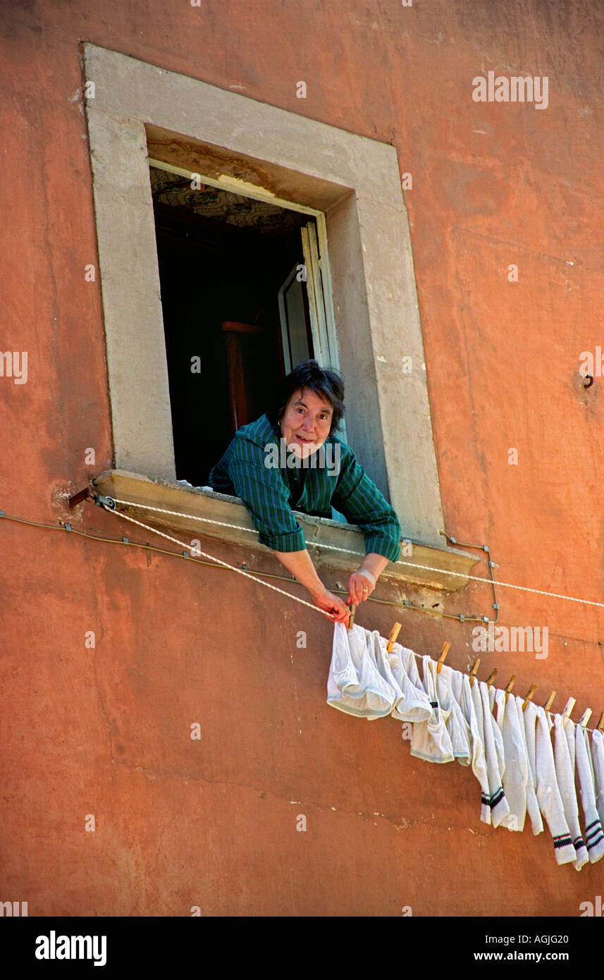 Woman hanging laundry out window hi-res stock photography and images - Alamy