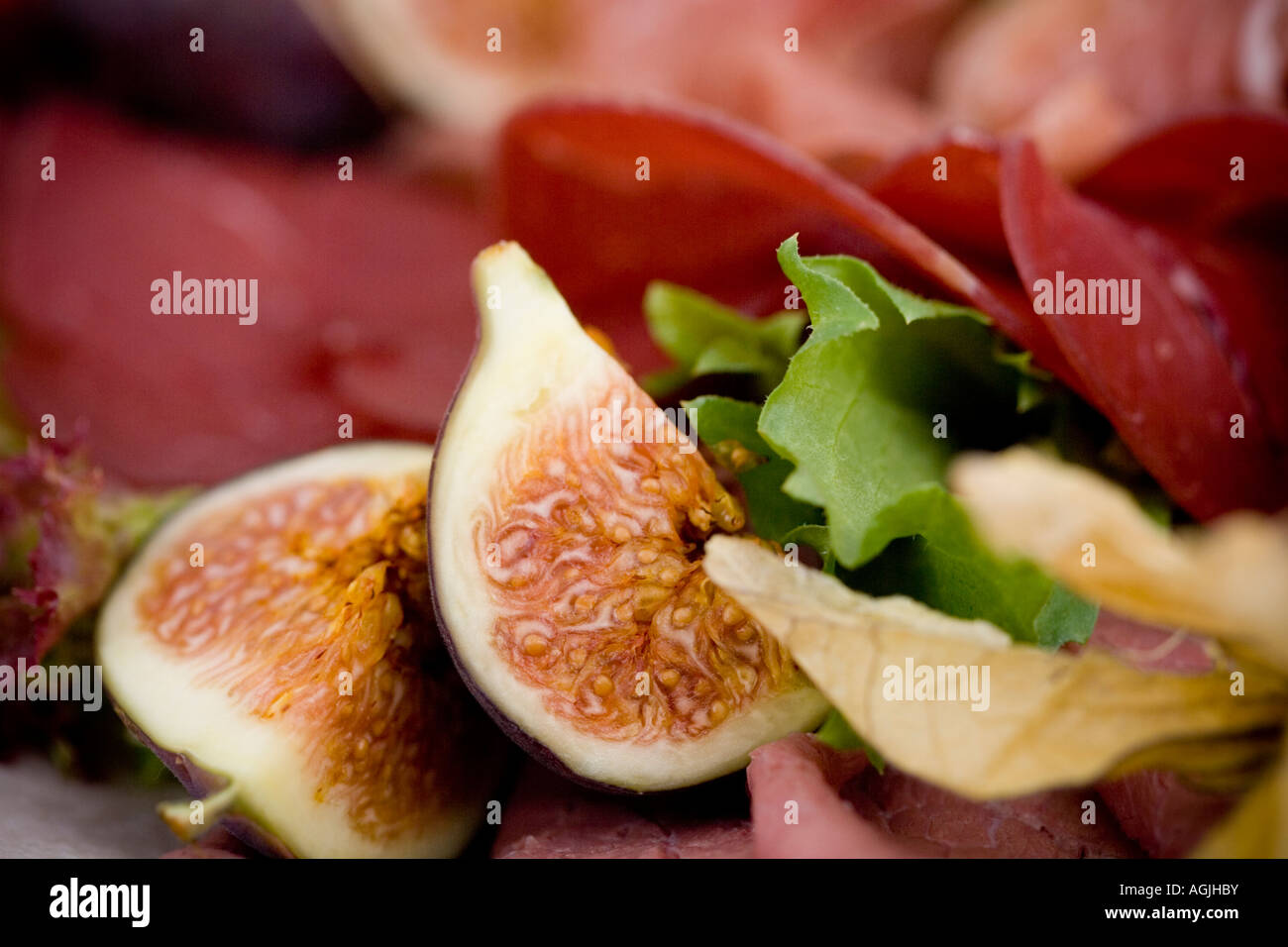 Sliced fig with selection of cold meats Stock Photo