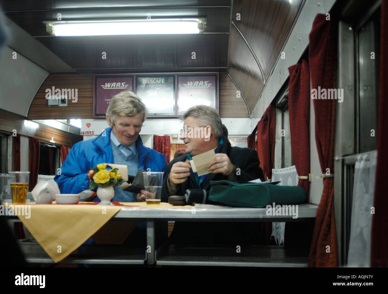 Two men chatting and drinking while travelling on a Polish railways WARS buffet car in Poland Stock Photo
