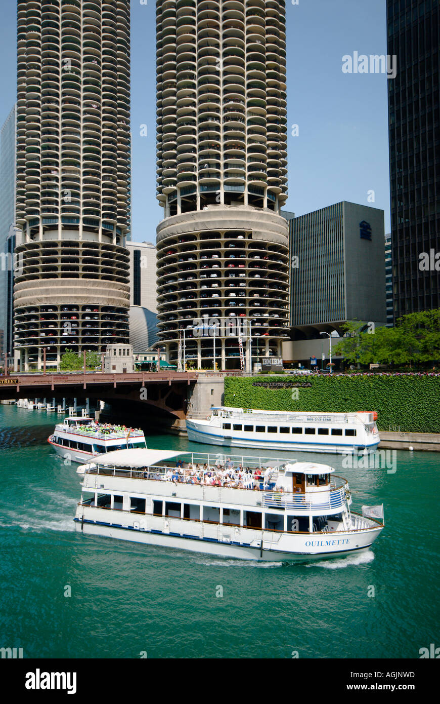 Tour boats ply the waters of the Chicago River under the twin round towers of Marina City in Chicago Illinois Stock Photo