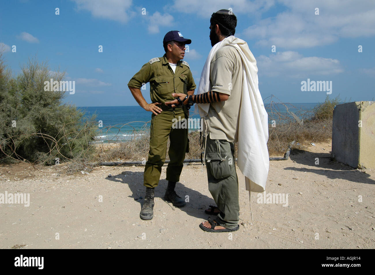 An Israeli military officer speaking to a Jewish settler wrapped with a Talit shawl in Gush Katif bloc of 17 Israeli settlements in Gaza strip Stock Photo