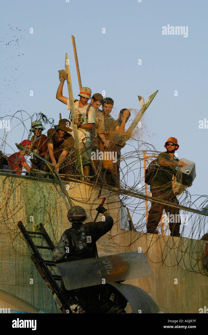 Israeli policemen force their way to clear settlers from the roof of a synagogue in Kfar Darom Settlement during Israeli disengagement from Gaza Strip Stock Photo