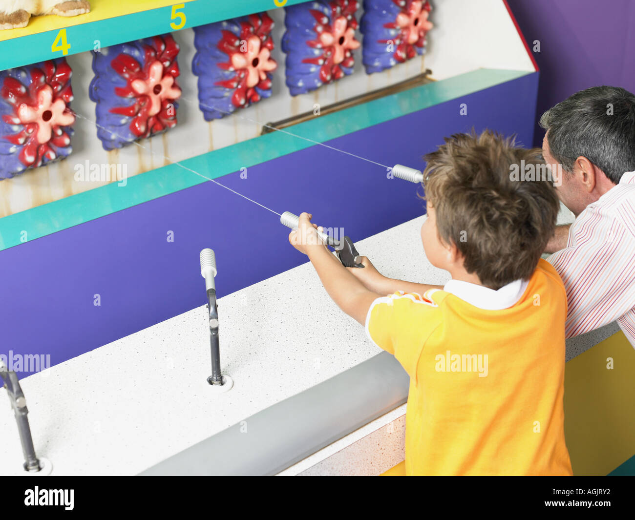 Father and son playing on fairground stall Stock Photo