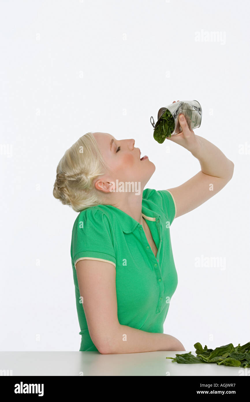 Young woman eating spinach Stock Photo Alamy